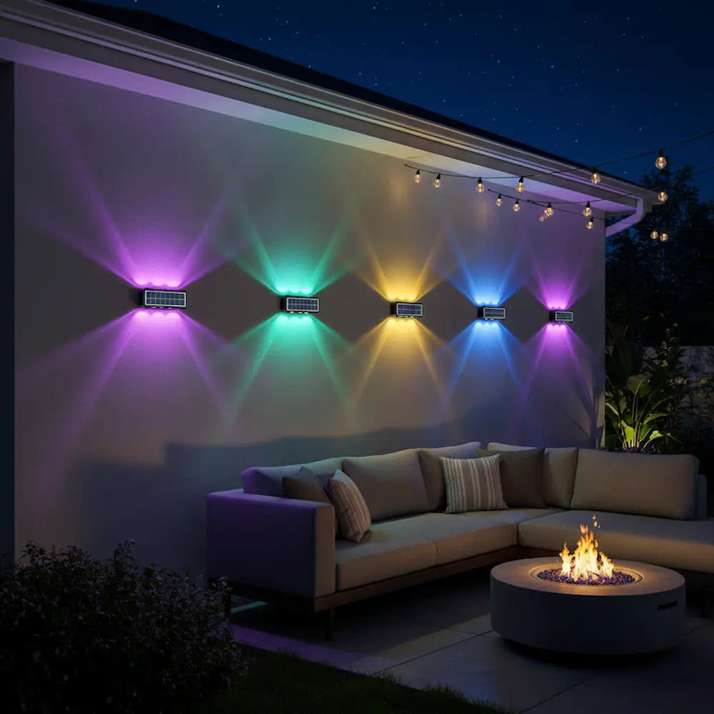 Outdoor setting with colorful wall lights and a fire pit at night.