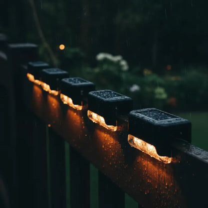 String lights on a wooden railing with a dark, rainy background