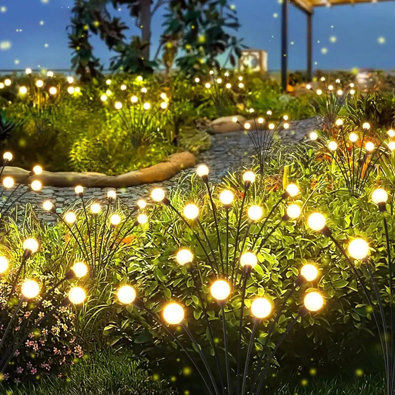 Garden at night with string lights illuminating plants and pathway