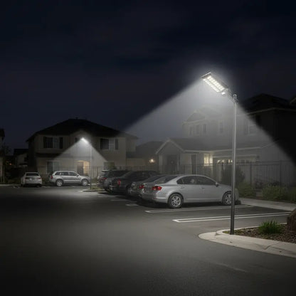 Street light illuminating a parking area with cars at night