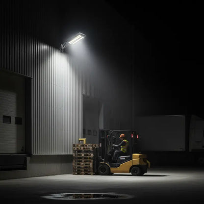Forklift operating in a dark warehouse with a spotlight illuminating the area.