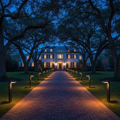 Stately home at night with a well-lit pathway