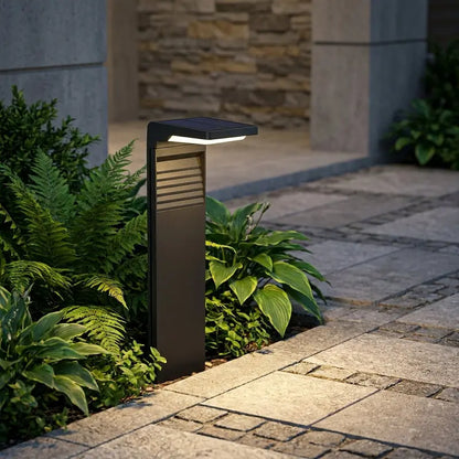 Outdoor garden light fixture on a stone pathway with plants and stone wall background
