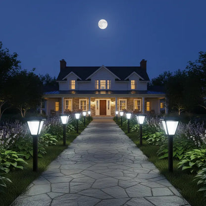 Stately home at night with a moonlit sky and well-lit pathway.
