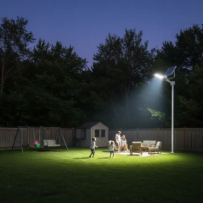 Family gathered under a solar-powered streetlight in a backyard at night.