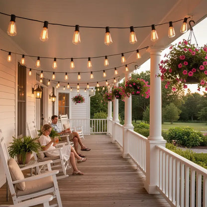 People sitting on a porch with string lights and hanging flower baskets.