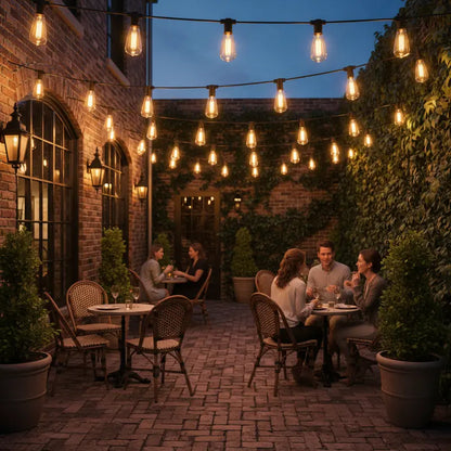 People dining outdoors at dusk with string lights and brick walls.