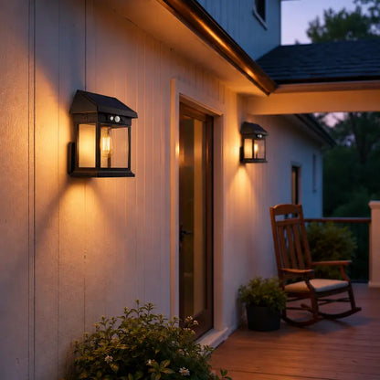 Outdoor setting with wall lights, rocking chair, and plants on a porch.