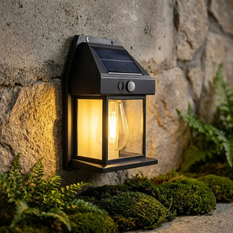 Solar-powered outdoor wall light fixture on a stone wall with greenery.