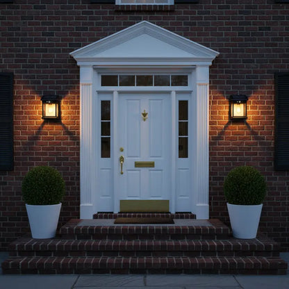 White door with gold handle on a brick wall at night